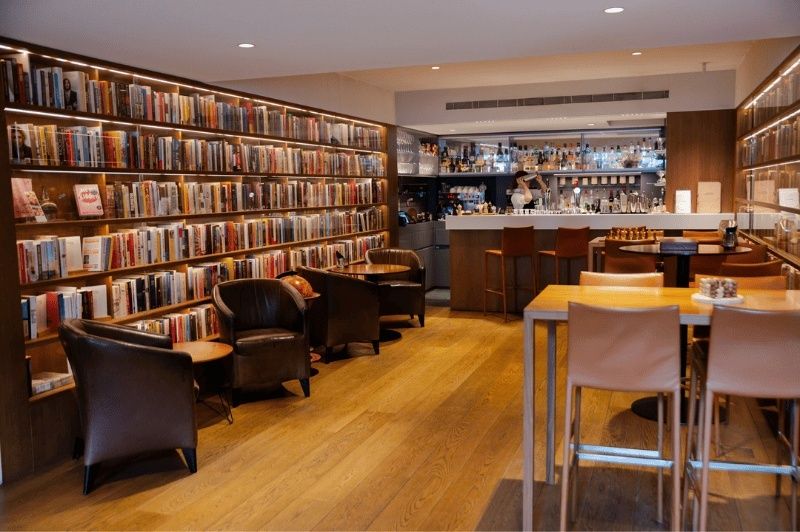 Elegante Hotelbibliothek mit Bücherwänden, Sesseln und integrierter Bar